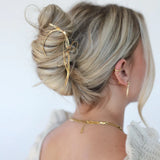 Kaxi Bow Pin in gold holding a loose blonde updo, back view