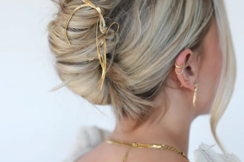 Kaxi Bow Pin in gold holding a loose blonde updo, back view
