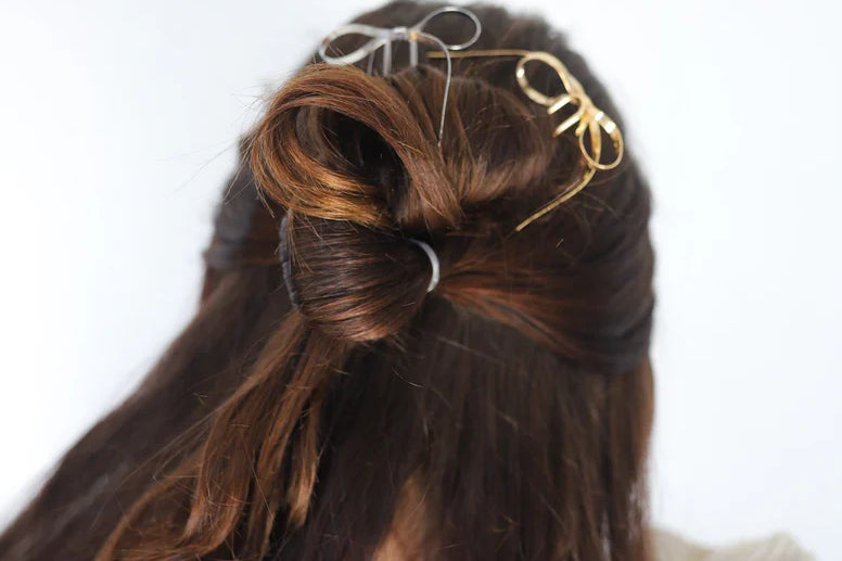 Kaxi Bow Pins in Silver and gold tucked into a half-up brunette hairstyle
