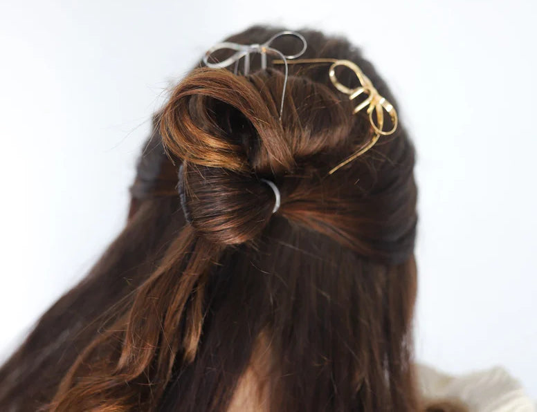 Kaxi Bow Pins in Silver and gold tucked into a half-up brunette hairstyle