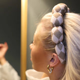 Close-up of the braided checkered Kaxi GRWM Headband in Beige worn in blonde hair