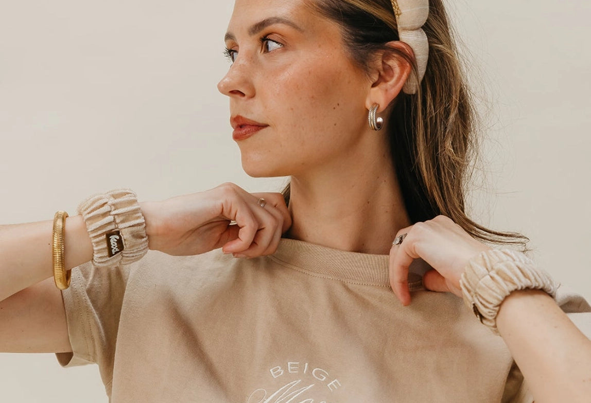 Woman in a beige tee wearing the Kaxi GRWM Headband and Wristbands in Beige, looking to the side