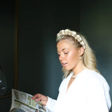 Woman in a white blouse reading while wearing the Kaxi GRWM Headband in Beige