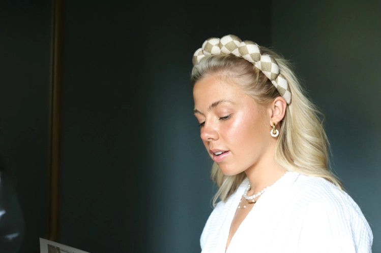 Woman in a white blouse reading while wearing the Kaxi GRWM Headband in Beige