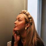 Woman in profile wearing the Kaxi GRWM Headband in Neutral Checkered