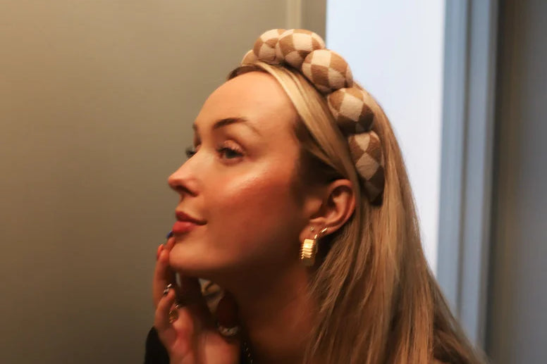 Woman in profile wearing the Kaxi GRWM Headband in Neutral Checkered