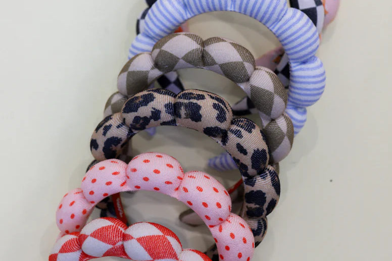 Stack of Kaxi GRWM Headbands in checkered, striped, leopard, floral and red patterns