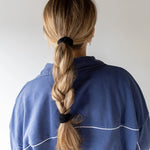 Kaxi The Hold All Day Hair Tie in Black holding a blonde braid, back view