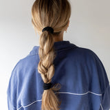 Kaxi The Hold All Day Hair Tie in Black holding a blonde braid, back view