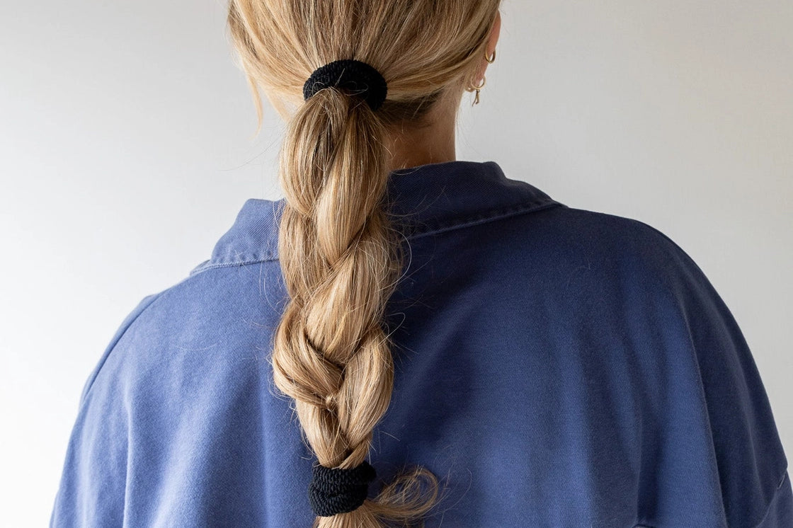 Kaxi The Hold All Day Hair Tie in Black holding a blonde braid, back view