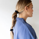 Kaxi The Hold All Day Hair Tie in Black holding a braid, side profile view