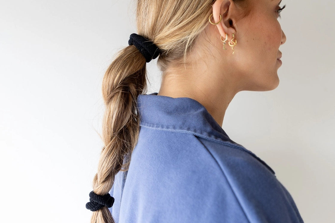 Kaxi The Hold All Day Hair Tie in Black holding a braid, side profile view