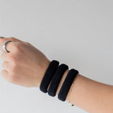 Kaxi The Hold All Day Hair Ties in Black worn stacked on a wrist
