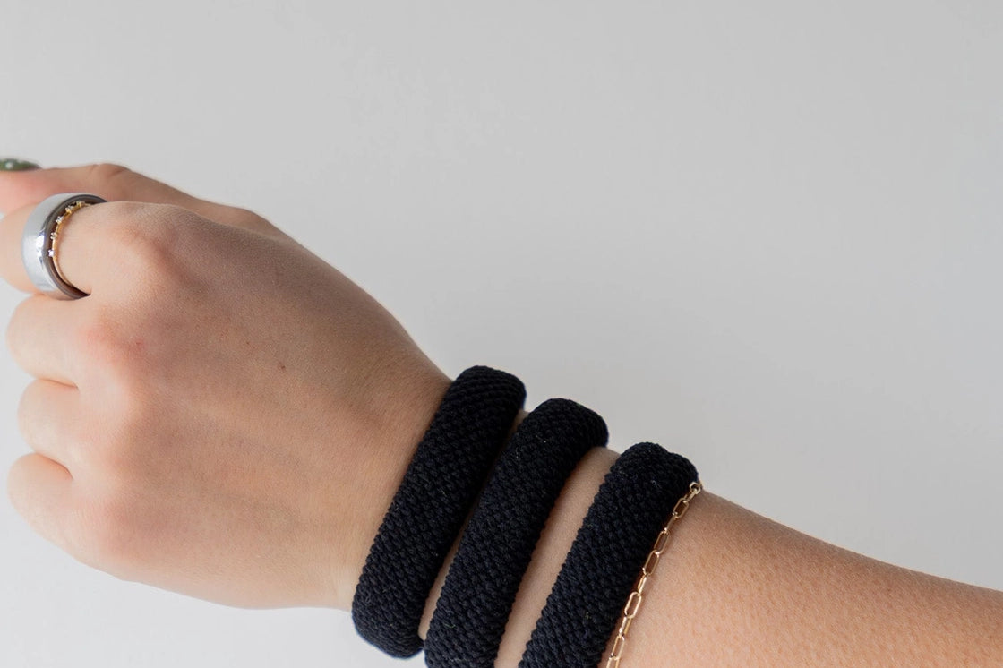 Kaxi The Hold All Day Hair Ties in Black worn stacked on a wrist