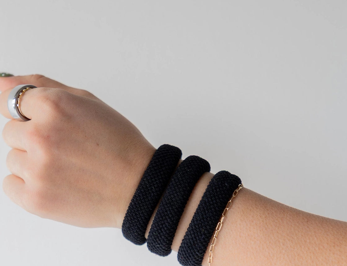 Kaxi The Hold All Day Hair Ties in Black worn stacked on a wrist
