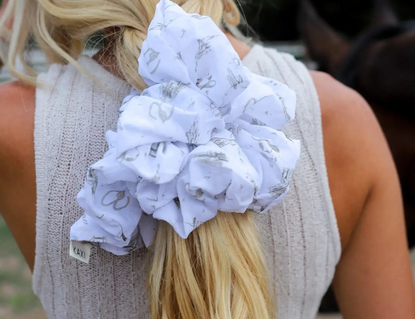 Kaxi Jumbo Coastal Cowgirl Scrunchie in periwinkle blue floral tied in a blonde ponytail, back view