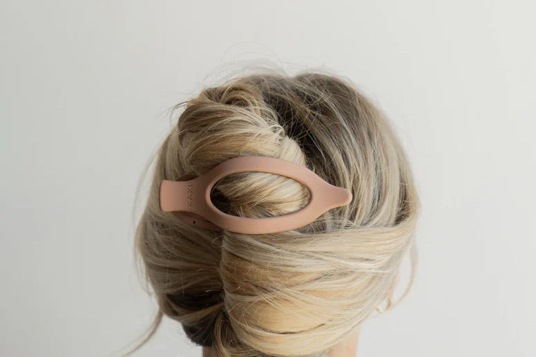 Kaxi Lay Down Claw 2.0 in blush pink holding a French twist, back view