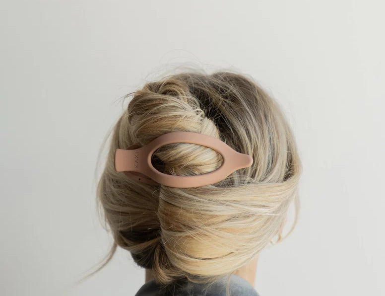 Kaxi Lay Down Claw 2.0 in blush pink holding a French twist, back view