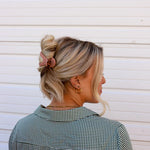 Kaxi Lay Down Claw 2.0 in Champagne holding a loose updo, side back view