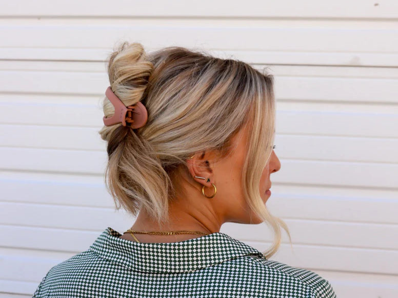 Kaxi Lay Down Claw 2.0 in Champagne holding a loose updo, side back view