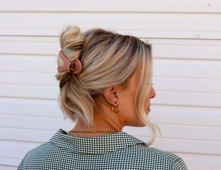 Kaxi Lay Down Claw 2.0 in Champagne holding a loose updo, side back view