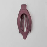 Kaxi Lay Down Claw 2.0 in Plum, a slim oval claw clip on a gray background