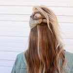 Kaxi Lay Down Claw 2.0 in taupe holding a half-up style in long blonde hair, back view