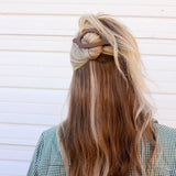 Kaxi Lay Down Claw 2.0 in taupe holding a half-up style in long blonde hair, back view