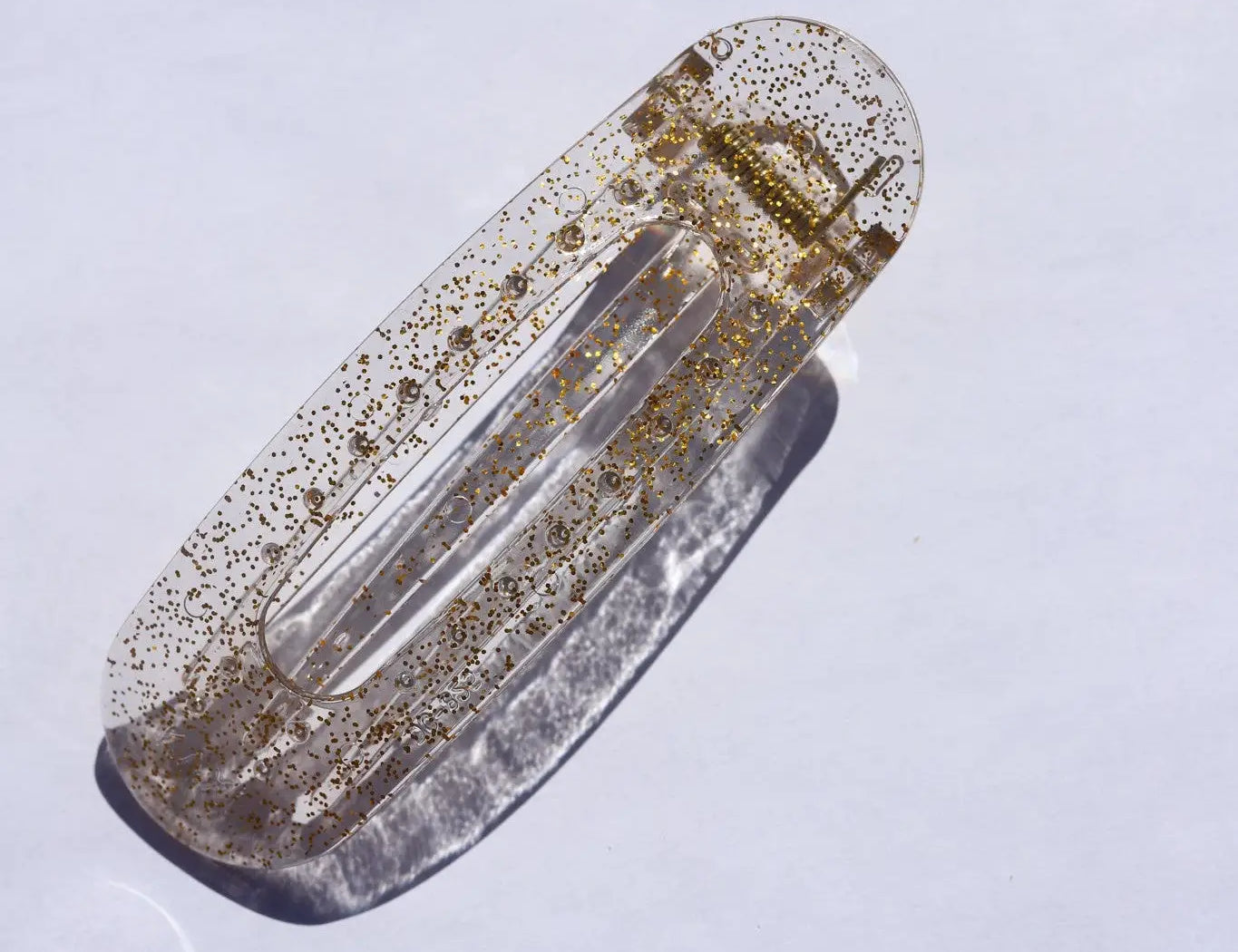 Kaxi Lay Down Claw hair clip in Clear Glitter, a translucent clip with gold glitter flecks