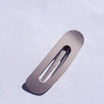 Kaxi Lay Down Claw hair clip in Matte Lavender, a flat rectangular claw clip on a blue background