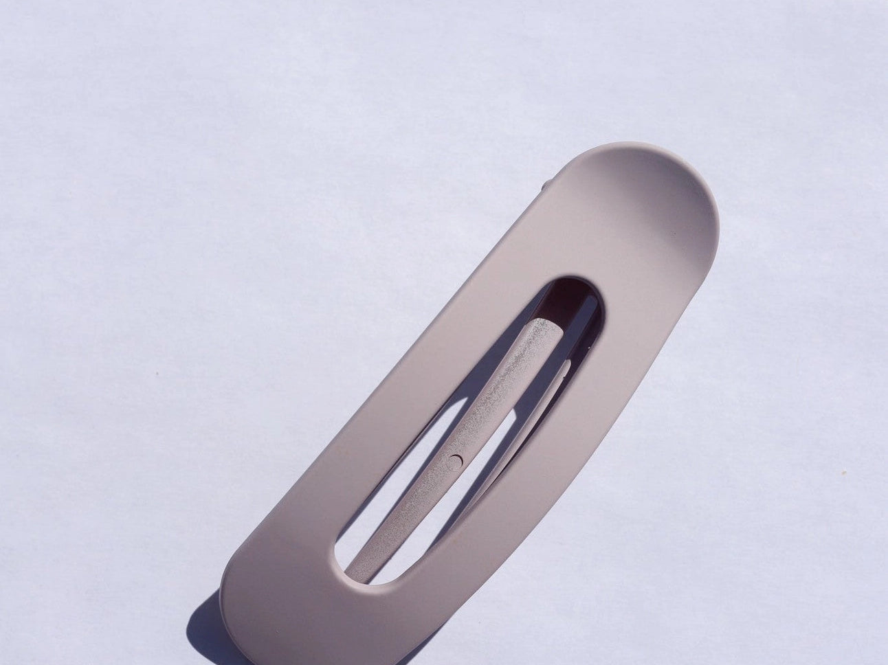 Kaxi Lay Down Claw hair clip in Matte Lavender, a flat rectangular claw clip on a blue background