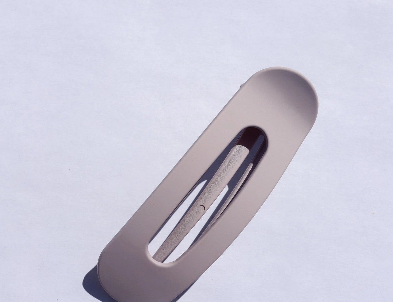 Kaxi Lay Down Claw hair clip in Matte Lavender, a flat rectangular claw clip on a blue background