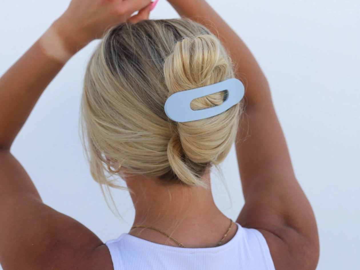 Kaxi Lay Down Claw hair clip in Matte Pale Blue holding a low bun, back view