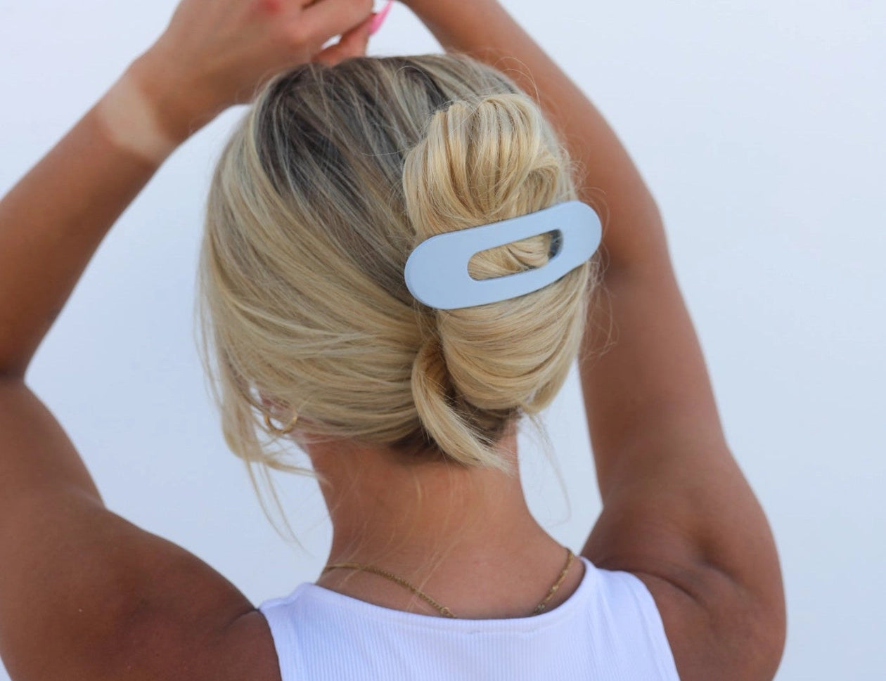 Kaxi Lay Down Claw hair clip in Matte Pale Blue holding a low bun, back view