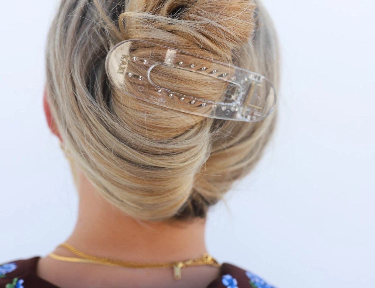 Kaxi Lay Down Claw hair clip in Shiny Clear holding a French twist, back view