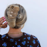 Kaxi Lay Down Claw hair clip in Shiny Clear holding a twisted updo, close-up back view