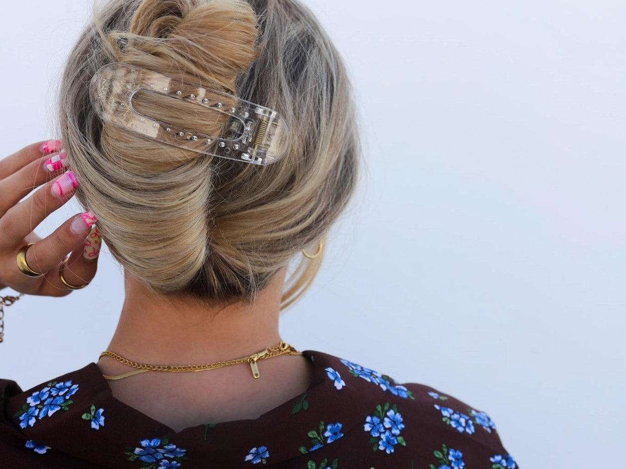 Kaxi Lay Down Claw hair clip in Shiny Clear holding a twisted updo, close-up back view