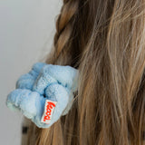 Close-up of the Kaxi Midi Towel Scrunchie in Baby Blue on a braid