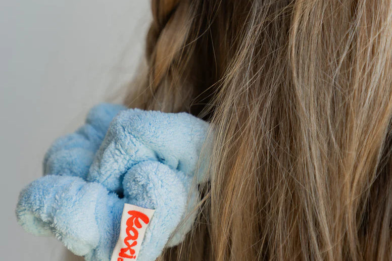 Close-up of the Kaxi Midi Towel Scrunchie in Baby Blue on a braid