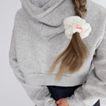 Kaxi Midi Towel Scrunchie in Cream tied in a side ponytail, back view