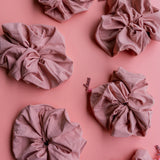 Kaxi Oversized Workout Scrunchies in Blush Pink scattered on a pink background