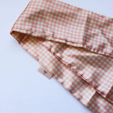 Kaxi Pink Plaid Hair Scarf, a pink and cream gingham satin scarf, folded on white