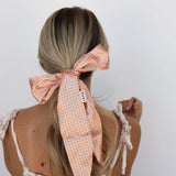 Kaxi Pink Plaid Hair Scarf tied around a low ponytail with long tails, back view