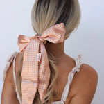 Kaxi Pink Plaid Hair Scarf tied in a bow around a blonde ponytail, back view