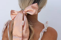Kaxi Pink Plaid Hair Scarf tied in a bow around a blonde ponytail, back view