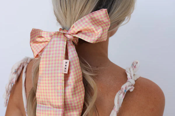 Kaxi Pink Plaid Hair Scarf tied in a bow around a blonde ponytail, back view