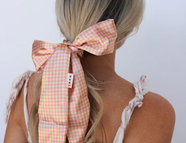 Kaxi Pink Plaid Hair Scarf tied in a bow around a blonde ponytail, back view