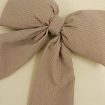 Kaxi Puffy Bow in Bloom, a taupe textured fabric bow, close-up