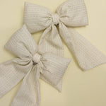 Kaxi Puffy Bows in cream and taupe laid together