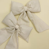 Kaxi Puffy Bows in cream and taupe laid together